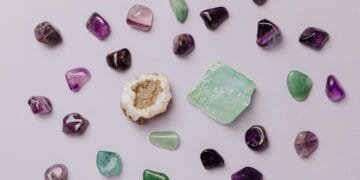 Flat lay of assorted polished gemstones including amethyst and jade on a light background.
