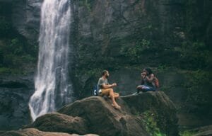 A serene moment captured by a waterfall in India with a couple enjoying nature's beauty together.