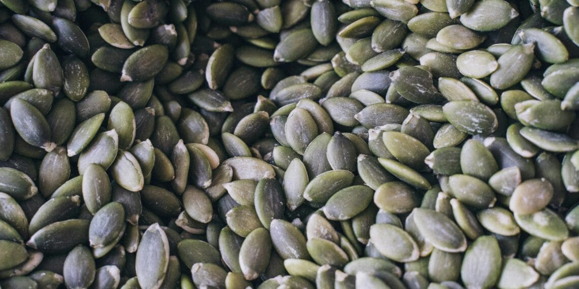 A close-up shot of organic pumpkin seeds showcasing their natural texture and green hue.