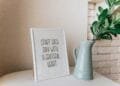 Framed quote 'Start each day with a grateful heart' next to a vase indoors.