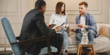 A counseling session with a diverse group of adults discussing issues in a cozy setting.